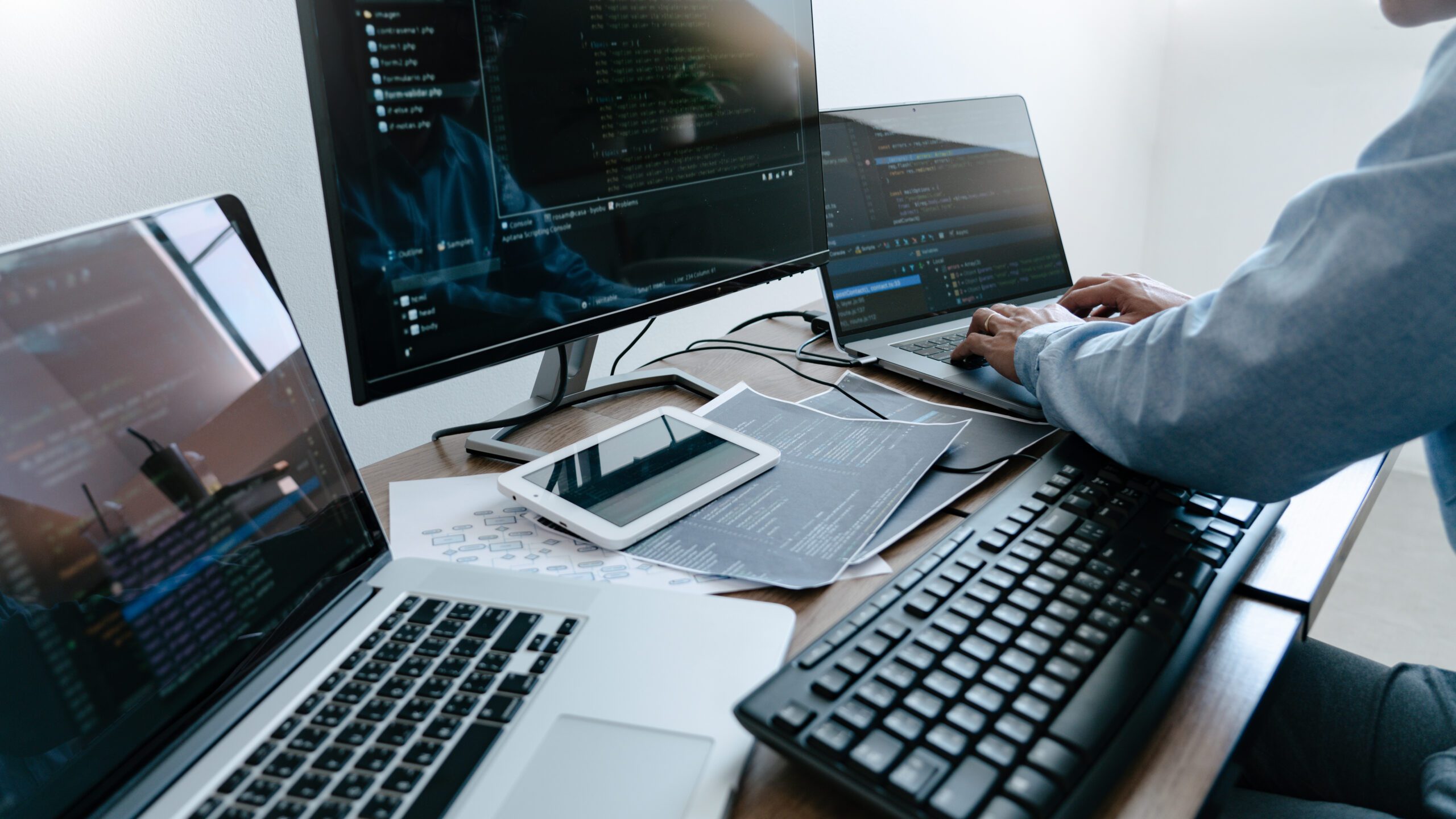 A network admin at a station with 3 monitors